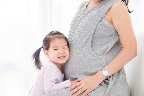 kid-with-her-prenancy-mom_1072877318-scaled